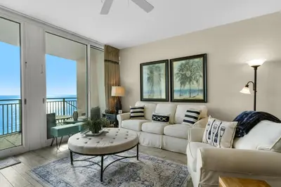 a living room with white furniture and a balcony at Aqua 0904 in Panama City Beach