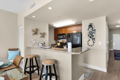 a kitchen with a counter and stools in a room at Aqua 0904 in Panama City Beach