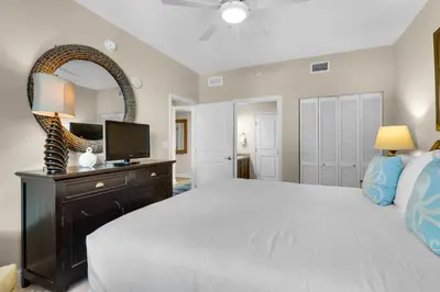 a bedroom with a large bed and a mirror at Aqua 0904 in Panama City Beach
