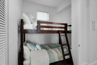 two bunk beds in a room with a bed at Aqua 2211 in Panama City Beach