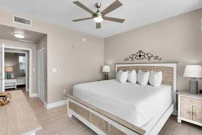 a bedroom with a white bed and a ceiling fan at Aqua 0503 in Panama City Beach