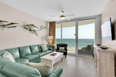 a living room with a green couch and a view of the ocean at Aqua 0503 in Panama City Beach