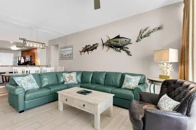 a living room with a green couch and a table at Aqua 0503 in Panama City Beach