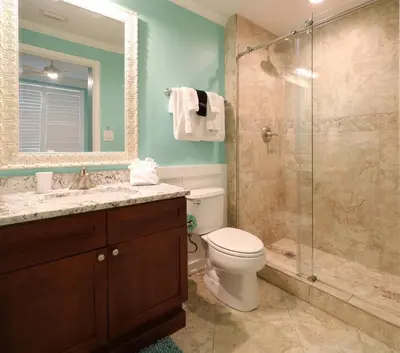 a bathroom with a toilet and a glass shower at Aqua 1409 in Panama City Beach