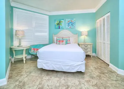 a bedroom with a white bed and two tables at Aqua 1409 in Panama City Beach