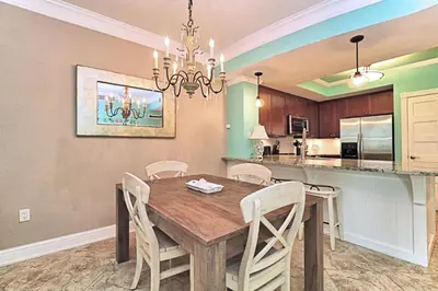 a dining room and kitchen with a wooden table and chairs at Aqua 1409 in Panama City Beach