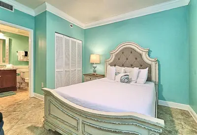 a bedroom with a white bed and blue walls at Aqua 1409 in Panama City Beach