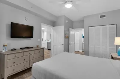 a bedroom with a bed and a tv on the wall at Aqua 0307 in Panama City Beach