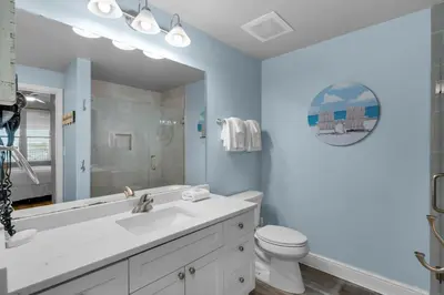 a bathroom with a sink and a toilet and a mirror at Aqua 0307 in Panama City Beach