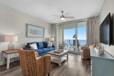 a living room with a blue couch and a table at Aqua 0307 in Panama City Beach