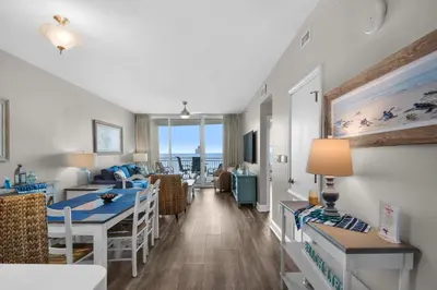 a living room and dining room with a view of the ocean at Aqua 0307 in Panama City Beach