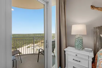 a bedroom with a bed and a balcony with a view at Aqua 1801 in Panama City Beach