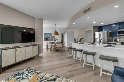 a kitchen and living room with a counter and chairs at Aqua 1801 in Panama City Beach