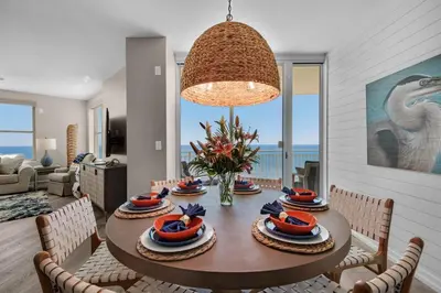 a dining room with a table and chairs with a view of the ocean at Aqua 1801 in Panama City Beach