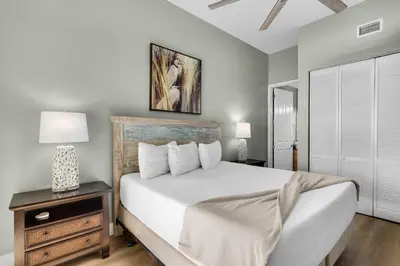 a bedroom with a large white bed and a nightstand at Aqua 0111 in Panama City Beach