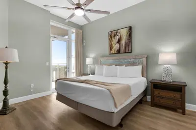 a bedroom with a large bed and a ceiling fan at Aqua 0111 in Panama City Beach