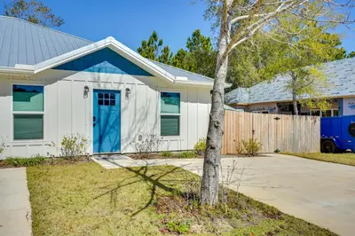 a house with a blue door and a tree at 1 Mi to Beach Dog-Friendly PCB Home with Backyard! in Panama City Beach