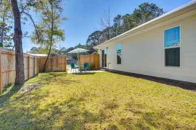a yard with a fence and a house at 1 Mi to Beach Dog-Friendly PCB Home with Backyard! in Panama City Beach
