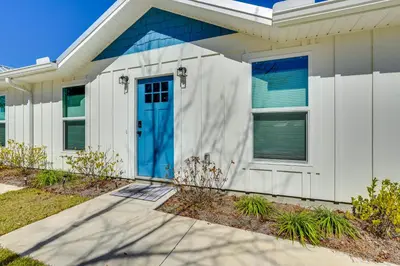 a white house with a blue door at 1 Mi to Beach Dog-Friendly PCB Home with Backyard! in Panama City Beach
