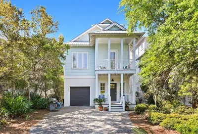 a white house with a porch and a driveway at Inlet Breeze in Inlet Beach