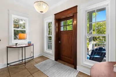 a living room with a wooden door and windows at Inlet Breeze in Inlet Beach