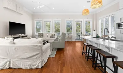 a white living room with a bed and a kitchen at Inlet Breeze in Inlet Beach