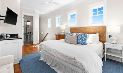 a bedroom with a large bed with a blue rug at Inlet Breeze in Inlet Beach