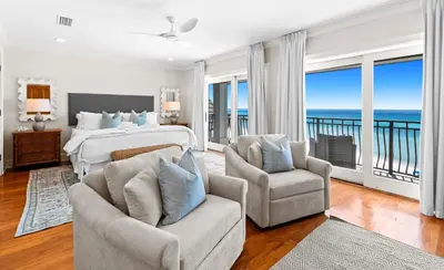 a bedroom with a bed and two chairs at Five Star in Inlet Beach