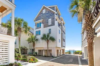 a house with palm trees in front of it at Five Star in Inlet Beach