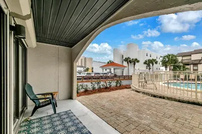 a patio with a chair and a swimming pool at Dune Villas 6A in Santa Rosa Beach