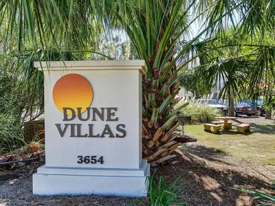 a sign for dune villas with a palm tree behind it at Dune Villas 6A in Santa Rosa Beach