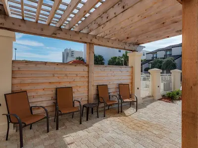 a group of chairs sitting under a wooden pergola at Dune Villas 6A in Santa Rosa Beach
