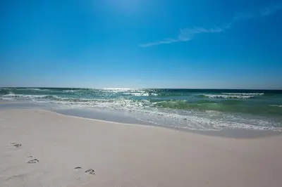 a beach with footprints in the sand and the ocean at Dune Villas 6A in Santa Rosa Beach
