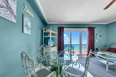 a dining room with a glass table and chairs at The Summit 1209 in Panama City Beach