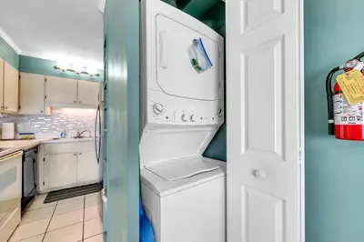 a kitchen with a washer and a white refrigerator at The Summit 1209 in Panama City Beach