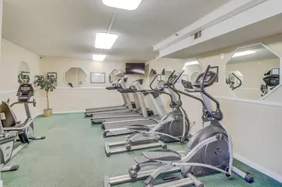 a gym with several treadmills and elliptical machines at The Summit 1209 in Panama City Beach