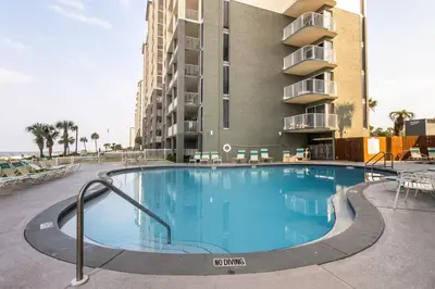 a large swimming pool in front of a building at Panama City Condo Rental Studio with Private Beach Access in Panama City Beach