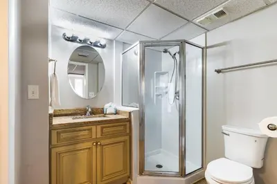 a bathroom with a shower and a toilet and a sink at Panama City Condo Rental Studio with Private Beach Access in Panama City Beach