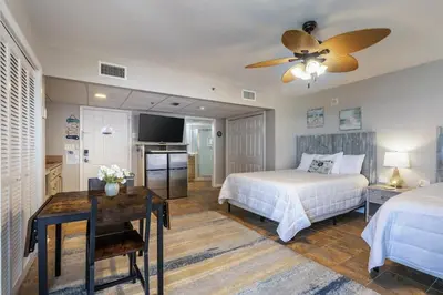 a bedroom with two beds and a ceiling fan at Panama City Condo Rental Studio with Private Beach Access in Panama City Beach