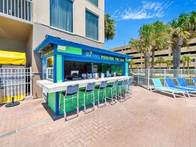 a bar with chairs in front of a building at Tidewater 716 in Panama City Beach