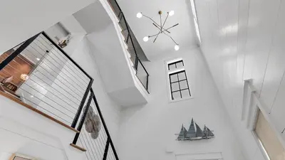 a staircase in a house with a clock on the ceiling at Beach Sea-kers Retreat by AvantStay Rooftop Deck w Views Pool Luxury 5BDR in Inlet Beach