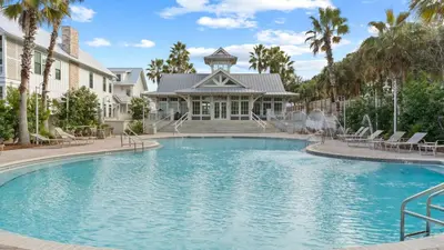 a swimming pool in front of a house with palm trees at Beach Sea-kers Retreat by AvantStay Rooftop Deck w Views Pool Luxury 5BDR in Inlet Beach