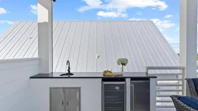 a kitchen island on a balcony with a roof at Beach Sea-kers Retreat by AvantStay Rooftop Deck w Views Pool Luxury 5BDR in Inlet Beach