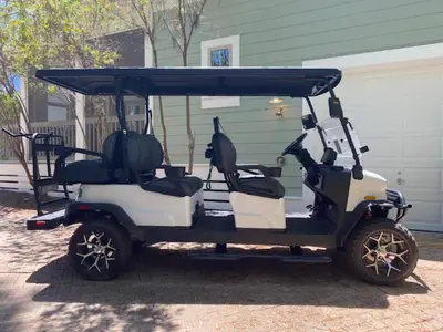 a golf cart parked in front of a house at The Cake Cottage in Santa Rosa Beach