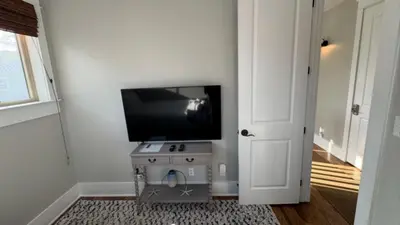 a room with a flat screen tv on a wall at The Cake Cottage in Santa Rosa Beach