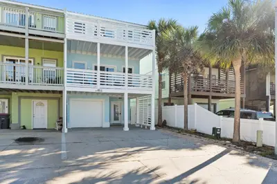 a large apartment building with palm trees in front of it at Beach House - Sunset Paradise by Panhandle Getaways in Panama City Beach