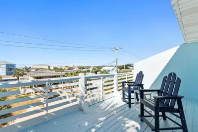 two chairs sitting on a deck looking out at the ocean at Beach House - Sunset Paradise by Panhandle Getaways in Panama City Beach