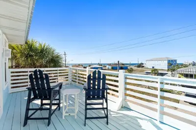 two chairs on a porch with a view of the ocean at Beach House - Sunset Paradise by Panhandle Getaways in Panama City Beach
