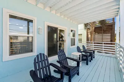 a porch with chairs and a table on a house at Beach House - Sunset Paradise by Panhandle Getaways in Panama City Beach
