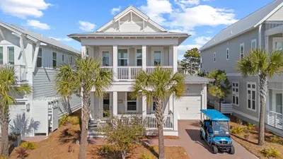 a house with palm trees in front of it at Resorting To Happiness by AvantStay Close to the Beach w Pool Access in Inlet Beach